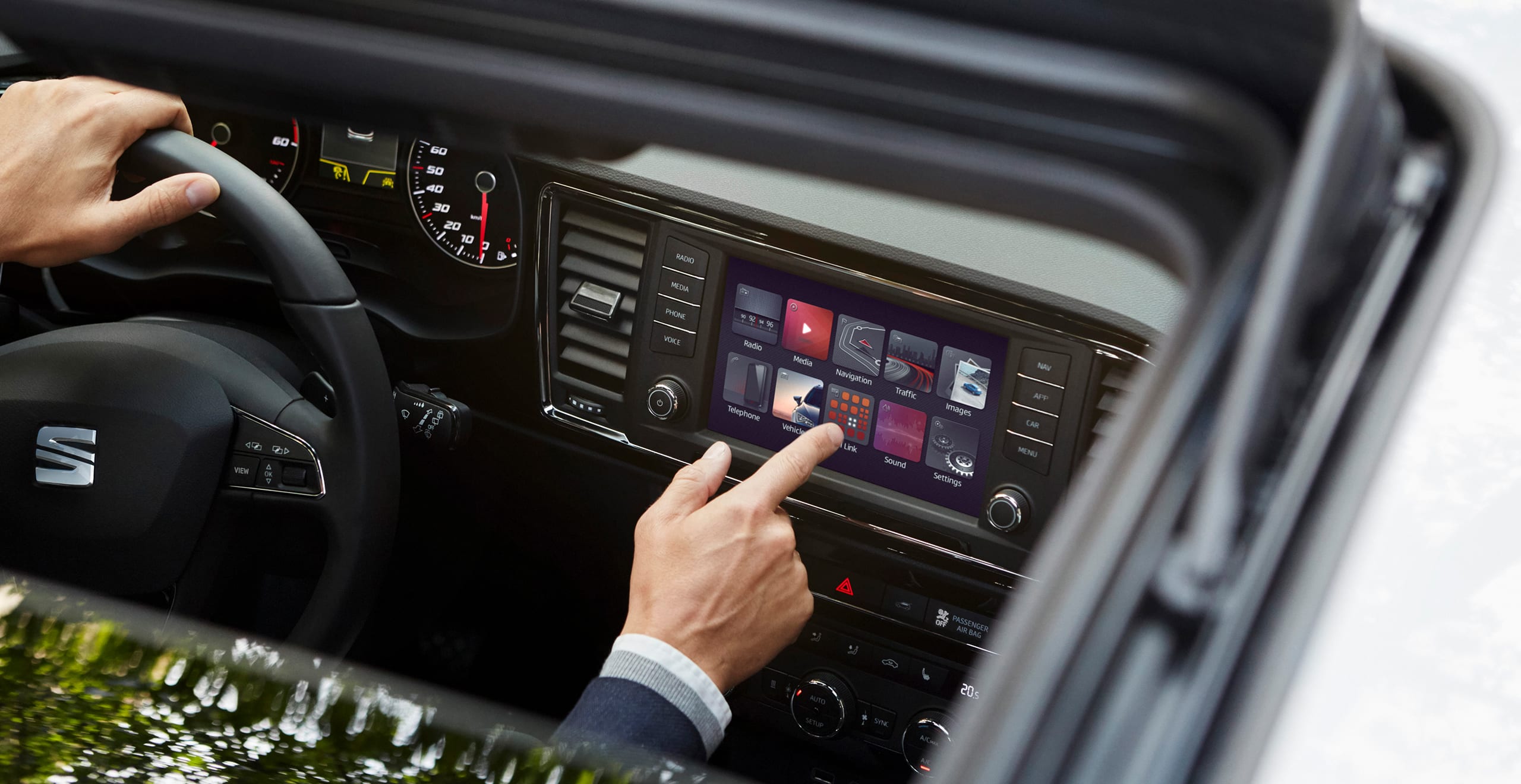 SEAT Ateca innovation and safety accessories. Showing a man with SEAT Full Link Technology Console: wireless mobile charging and app syncing