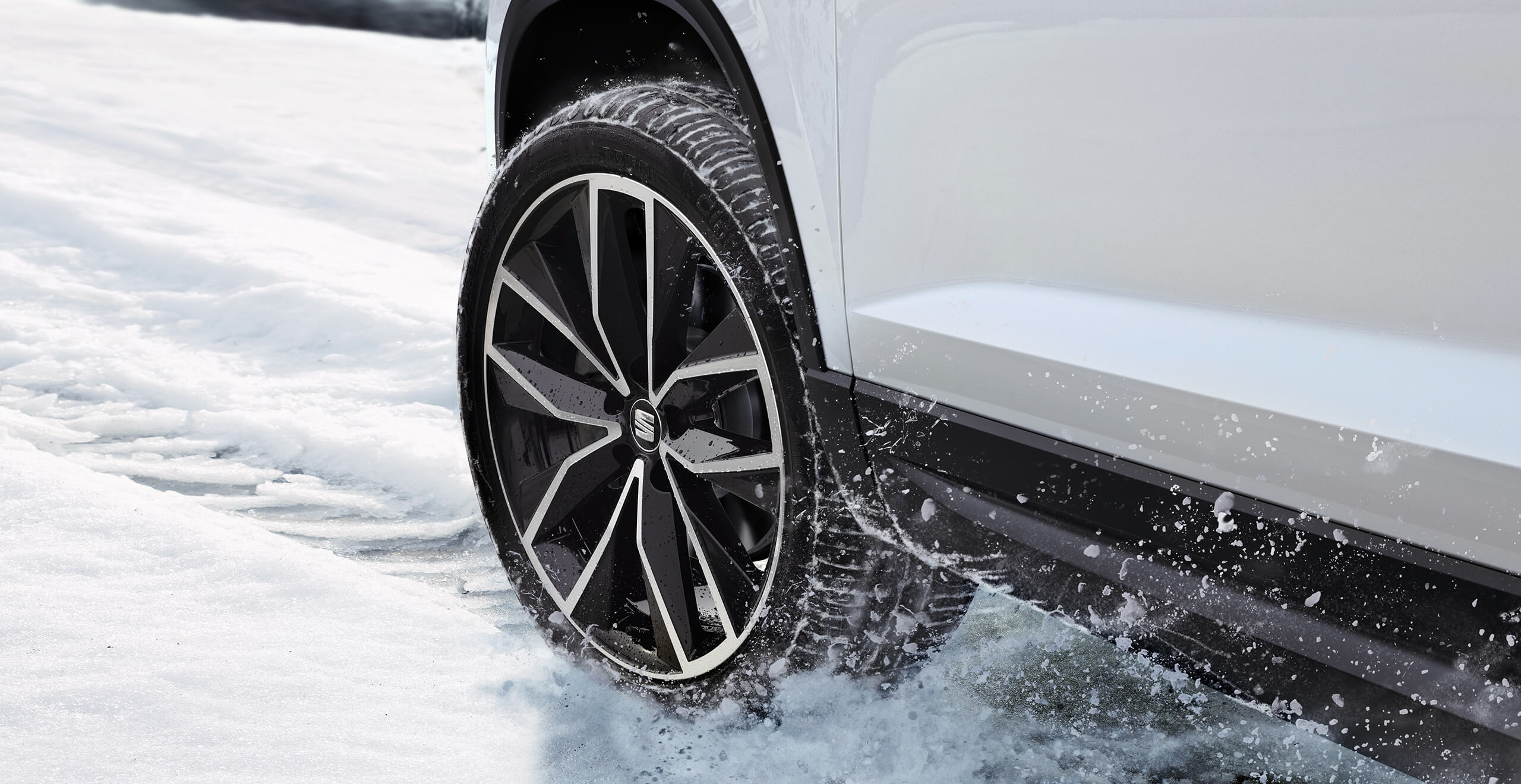 Showing a SEAT Ateca car wheel driving on a snowy road. Safe driving and control shows driving with SEAT Ateca 4Drive all-wheel drive system version