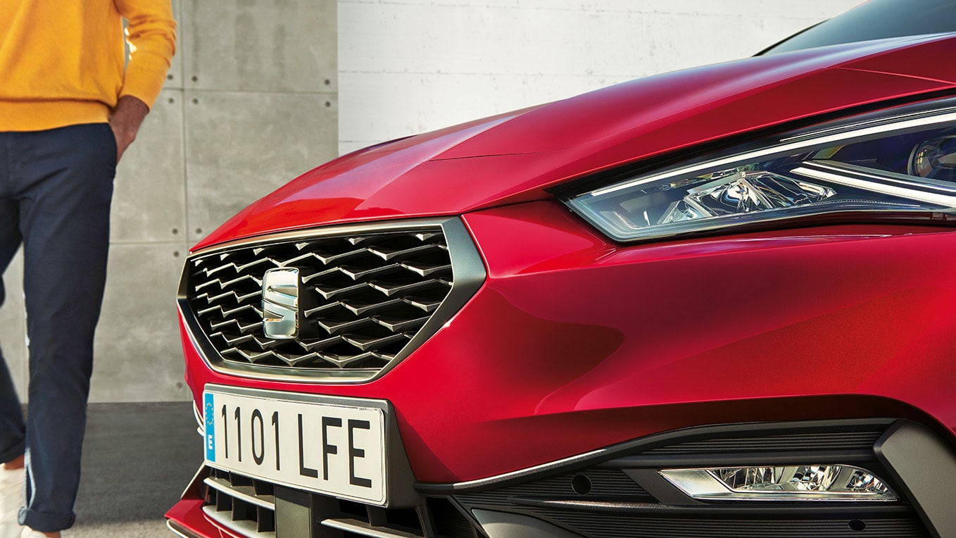 A close up of the SEAT Leon's front grille in desire red, showcasing its fierce and refined honeycomb pattern.