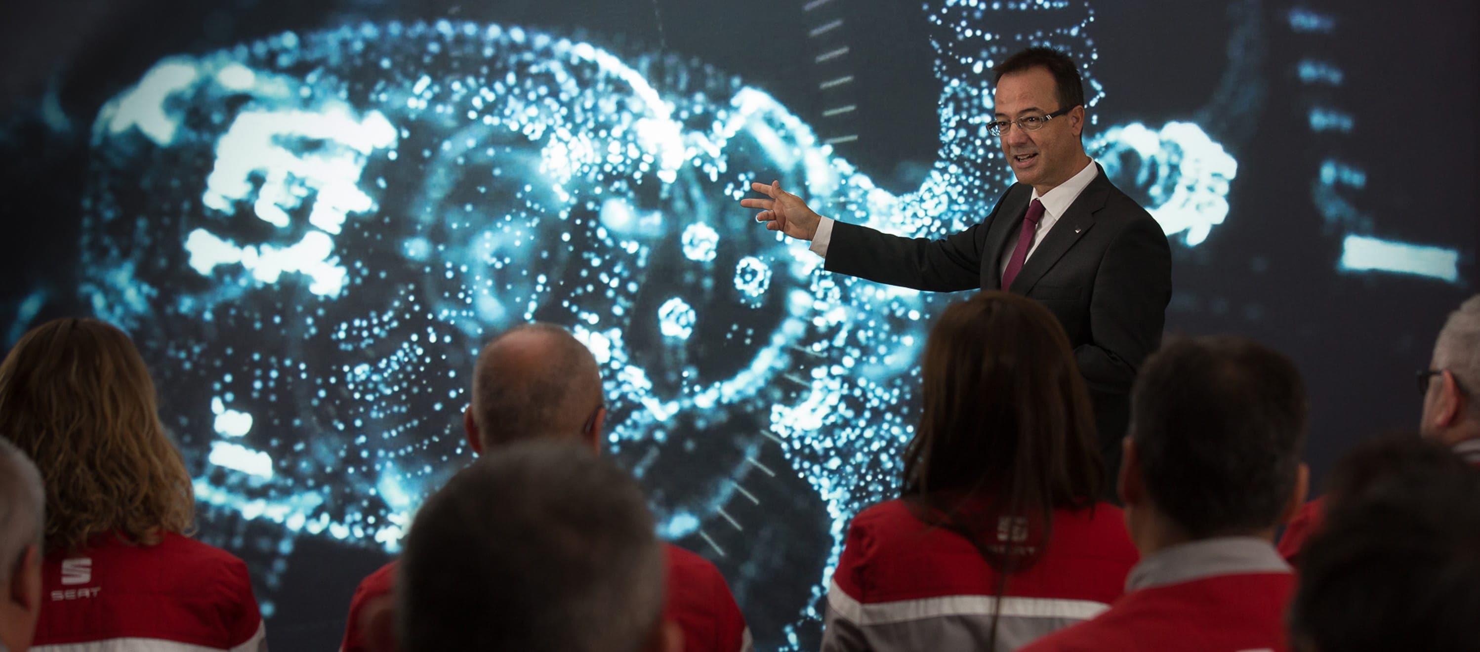 Man pointing at graph in front of SEAT Martorell workers – SEAT Human Resources