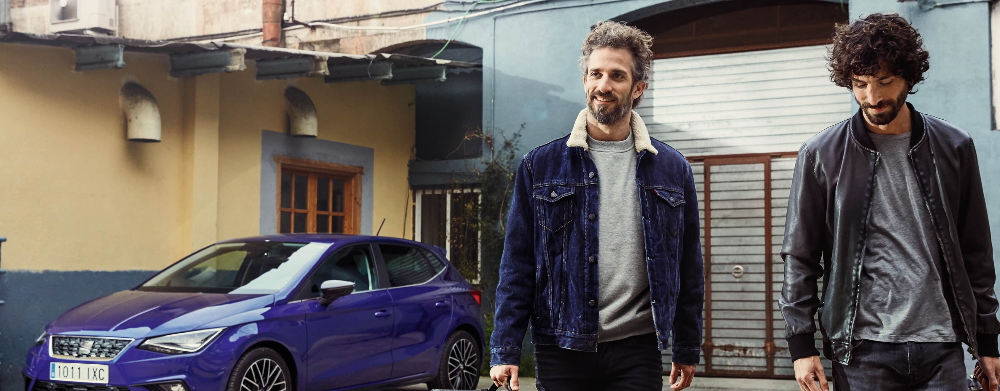 SEAT new car services and maintenance – two men with an amp walking with a SEAT Ibiza city car in the background