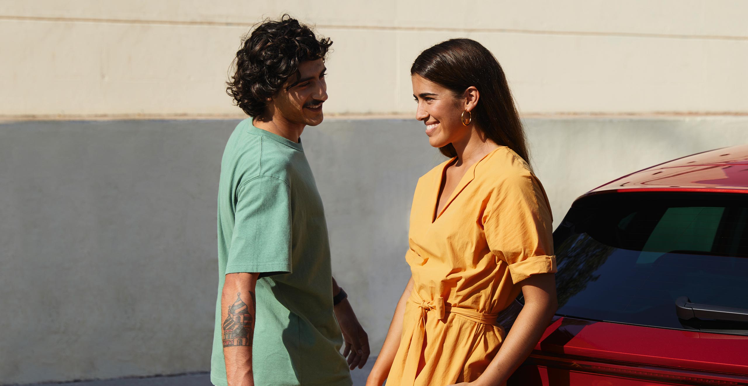 Couple talking next to a seat leon desire red colour